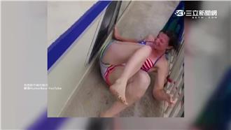 嚇！壯男拋女友入海  失敗狠撞欄杆
