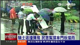 騎士追撞彈飛　民眾幫撐傘拿門板擋雨