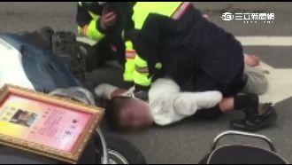誇張！男子當街攔車襲警　遭強制送醫