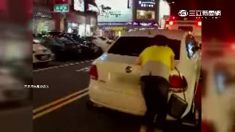 不甘愛車被拖　婦人竟趴車上一路滑行