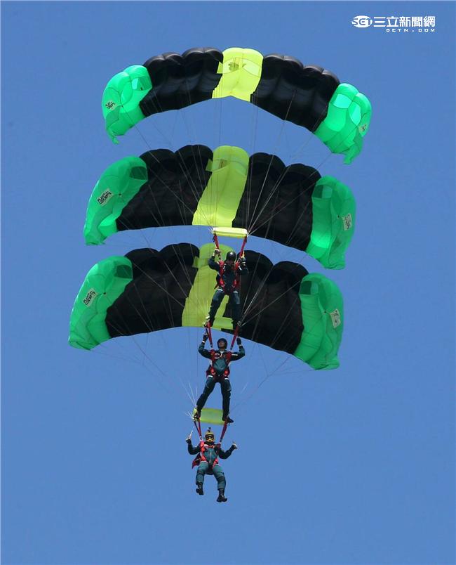 神龍小組成員三人踩肩疊傘，展現跳傘的專業技巧與精準。（記者邱榮吉/屏東拍攝）