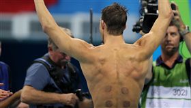 菲爾普斯比賽時，身上留有拔罐後的痕跡。（圖／美聯社／達志影像）