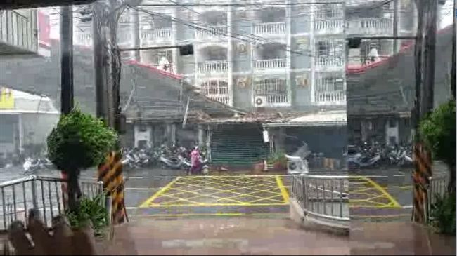 險！鐵皮雨棚被掀飛兩樓高　險砸騎士
