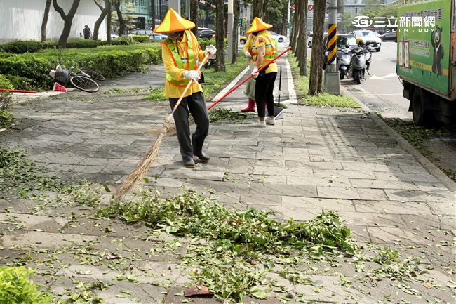 「梅姬」強風豪雨後帶來滿街落葉，清潔人員辛苦地清理。（記者邱榮吉/攝影）