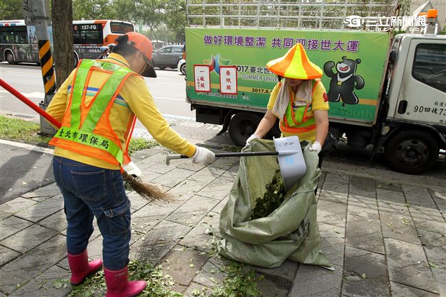 「梅姬」強風豪雨後帶來滿街落葉，清潔人員辛苦地清理。（記者邱榮吉/攝影）