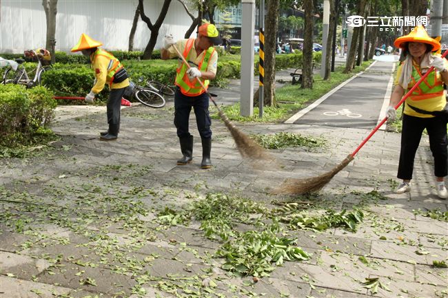 「梅姬」強風豪雨後帶來滿街落葉，清潔人員辛苦地清理。（記者邱榮吉/攝影）