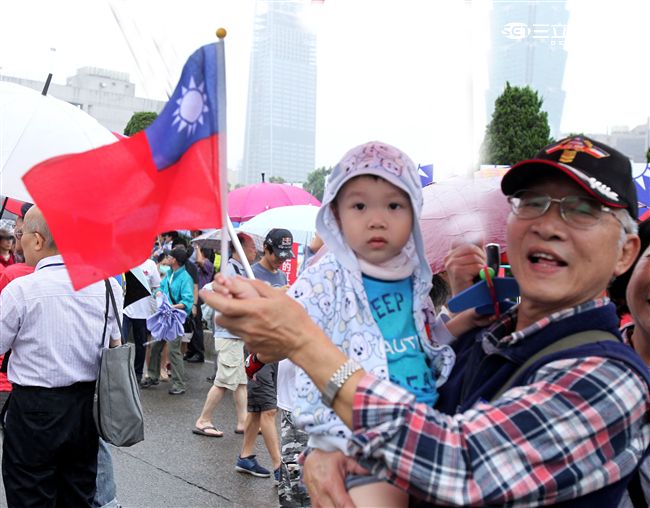 小朋友在爺爺帶領下揮著小國旗參加「我愛國旗嘉年華會｣。（記者邱榮吉/攝影）