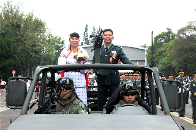 新人航特部兩棲蛙人朱程楠與太魯閣族的原住民姑娘吳美君搭乘特戰突擊車進場。（記者邱榮吉/攝影）