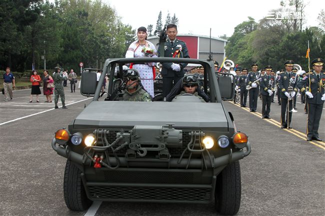 新人航特部兩棲蛙人朱程楠與太魯閣族的原住民姑娘吳美君搭乘特戰突擊車進場。（記者邱榮吉/攝影）