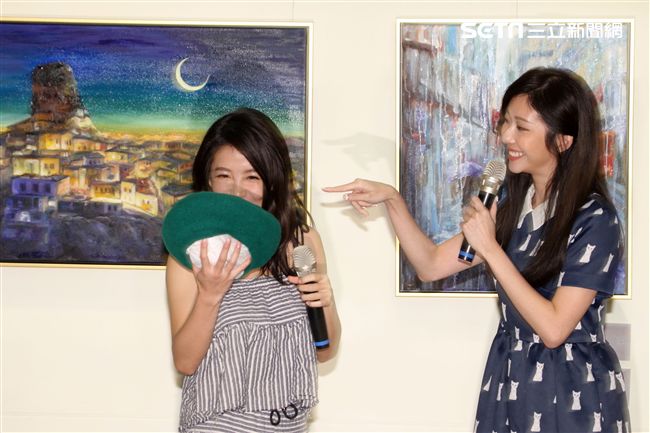 張景嵐「不可方物」創作聯展好友郭書瑤送上綠色畫家帽子，引起一陣聯想，現場笑聲不斷。（記者邱榮吉/攝影）