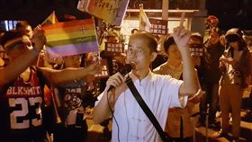 自稱「能量老師」的簡英（前中）10日到「讓生命不再逝去，為婚姻平權站出來」音樂會場外短講，主張另立「生活互助團體法」解決同婚問題，和現場同婚支持者
激烈辯論，最後被警方勸離。（圖／中央社）