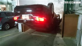 陳女開車欲進入停車場時，不慎誤踩油門導致暴衝，撞上前方閘門後180度往前翻，墜落至6公尺深的地面，所幸並未受傷。（翻攝畫面）