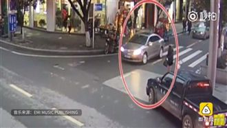 影／長髮辣妹心情差　邊過馬路邊灑錢