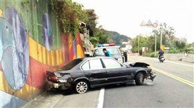 林男開BMW轎車遭警盤查加速逃逸，卻不慎失控撞上山壁，他只好棄車翻越圍牆逃離現場（翻攝畫面）