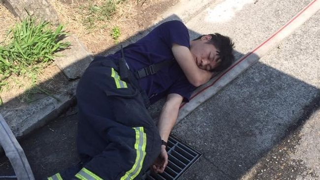 消防隊員忙滅火　累癱睡倒在水溝蓋上