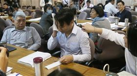 立法院司法及法制委員會19日初審攸關年金改革的各版本公務人員退休撫卹法草案，時代力量立委徐永明（前右）進入院區前，遭抗爭群眾拉扯、潑水，導致頭髮、上衣都濕透。徐永明進入會議室後，用紙巾擦拭身體。／中央社