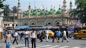 印度少數假日，必須由寺廟的祭司或清真寺的教士「觀天象」，看月亮圓不圓，再由政府公告隔天是否放假。圖為加爾各答一間清真寺前繁忙的街道。（檔案照片）中央社記者康世人加爾各答攝 106年4月20日