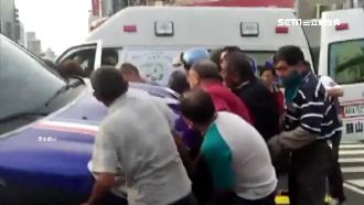 暖！騎士摔入車底　壯漢抬車幫救人