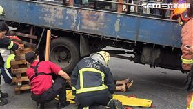 朱男騎車送貨不慎與貨車擦撞，整個人被捲入車底，民眾立刻報案並開堆高機撐起車體，順利救出受困的朱男（翻攝畫面）