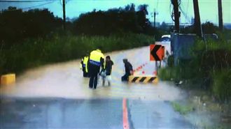 八里巴士困水中　暖警合扛四老翁脫困