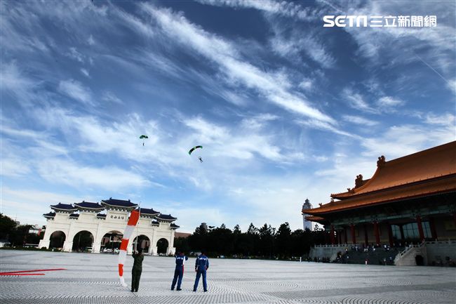 陸軍「神龍小組高空跳傘」在自由廣場前展現「翱翔天際現神龍｣由空訓中心派出8名神龍小組成員，攜帶國旗、三軍軍旗、彩帶、煙幕，區分兩波次實施，每波次各4員，執行4,500英呎高空疊傘「扇形、踩肩」及定點跳傘等操演任務。（記者邱榮吉/攝影）