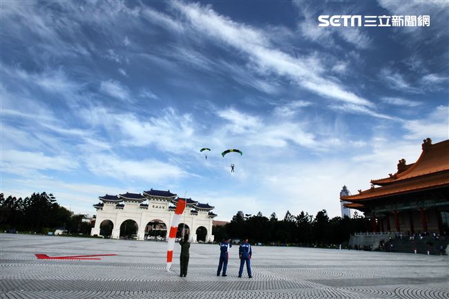 陸軍「神龍小組高空跳傘」在自由廣場前展現「翱翔天際現神龍｣由空訓中心派出8名神龍小組成員，攜帶國旗、三軍軍旗、彩帶、煙幕，區分兩波次實施，每波次各4員，執行4,500英呎高空疊傘「扇形、踩肩」及定點跳傘等操演任務。（記者邱榮吉/攝影）