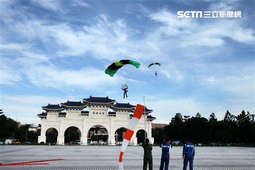 陸軍「神龍小組高空跳傘」在自由廣場前展現「翱翔天際現神龍｣由空訓中心派出8名神龍小組成員，攜帶國旗、三軍軍旗、彩帶、煙幕，區分兩波次實施，每波次各4員，執行4,500英呎高空疊傘「扇形、踩肩」及定點跳傘等操演任務。（記者邱榮吉/攝影）