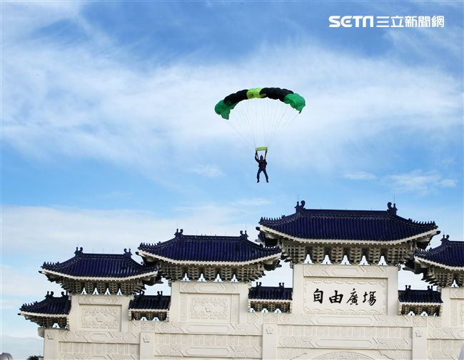 陸軍「神龍小組高空跳傘」在自由廣場前展現「翱翔天際現神龍｣由空訓中心派出8名神龍小組成員，攜帶國旗、三軍軍旗、彩帶、煙幕，區分兩波次實施，每波次各4員，執行4,500英呎高空疊傘「扇形、踩肩」及定點跳傘等操演任務。（記者邱榮吉/攝影）