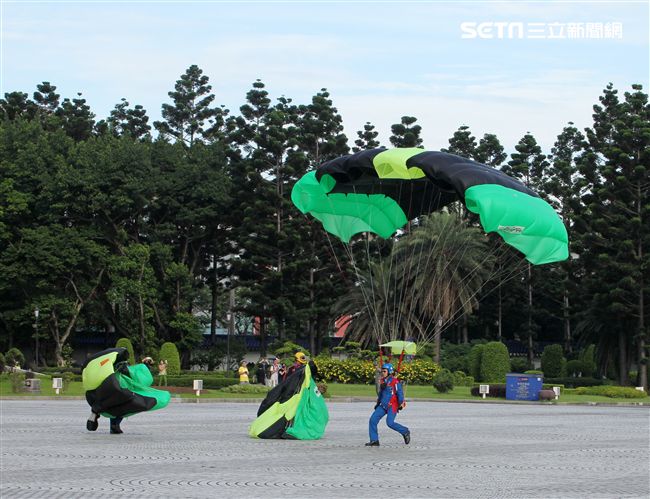 陸軍「神龍小組高空跳傘」在自由廣場前展現「翱翔天際現神龍｣由空訓中心派出8名神龍小組成員，攜帶國旗、三軍軍旗、彩帶、煙幕，區分兩波次實施，每波次各4員，執行4,500英呎高空疊傘「扇形、踩肩」及定點跳傘等操演任務。（記者邱榮吉/攝影）