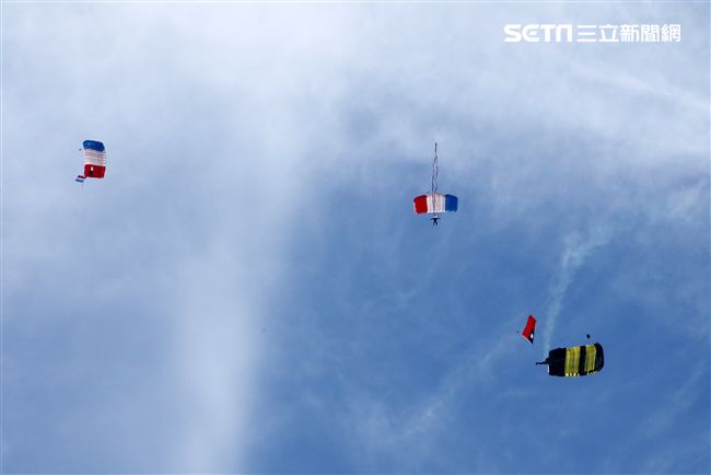 陸軍「神龍小組高空跳傘」在自由廣場前展現「翱翔天際現神龍｣由空訓中心派出8名神龍小組成員，攜帶國旗、三軍軍旗、彩帶、煙幕，區分兩波次實施，每波次各4員，執行4,500英呎高空疊傘「扇形、踩肩」及定點跳傘等操演任務。（記者邱榮吉/攝影）
