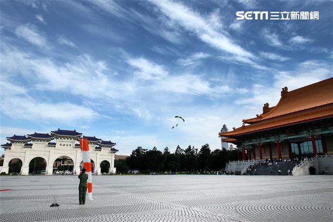 陸軍「神龍小組高空跳傘」在自由廣場前展現「翱翔天際現神龍｣由空訓中心派出8名神龍小組成員，攜帶國旗、三軍軍旗、彩帶、煙幕，區分兩波次實施，每波次各4員，執行4,500英呎高空疊傘「扇形、踩肩」及定點跳傘等操演任務。（記者邱榮吉/攝影）