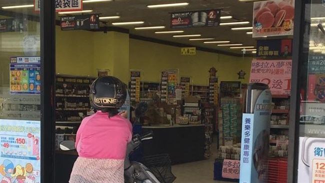 大媽坐機車卡住店門　邊吹冷氣邊等人