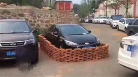 大陸遼寧三寶硬擋停車場轉彎處！請移車還掛電話…連夜被「紅磚包圍」(圖/翻攝自半島晨報)