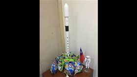  乖乖包圍承載福衛五號火箭模型，工程人員擺放了承載福衛五號的Falcon 9火箭模型，再用零食「乖乖」與國旗坐鎮，將火箭包圍祈福。圖／國家太空中心官員提供／中央社