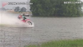 越野摩托車穿越埤塘。