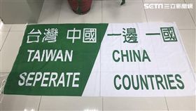 台灣國的陳姓男子在場內高舉「台灣中國 一邊一國」的旗幟，經憲兵勸阻不聽後遭帶回松山分局保護管束，他竟憲兵怒罵「目幹」，遭到警方依妨害公務罪送辦（楊忠翰攝）