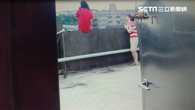 紅衣女泣坐樓頂欲輕生　勇消熊抱解圍