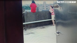 紅衣女泣坐樓頂欲輕生　勇消熊抱解圍