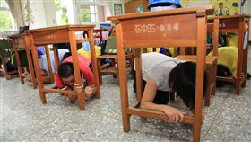 台中防災地震演練　落實正確逃生觀念台中市政府13日在防災地震避難掩護示範學校的石岡國中舉行演練，全校師生在黃金10分鐘內完成就地掩蔽、疏散路線演練及中央廚房火災搶救等。圖為模擬地震發生當下，教室內師生躲進課桌下方。（台中市政府提供）中央社記者趙麗妍傳真　106年9月13日