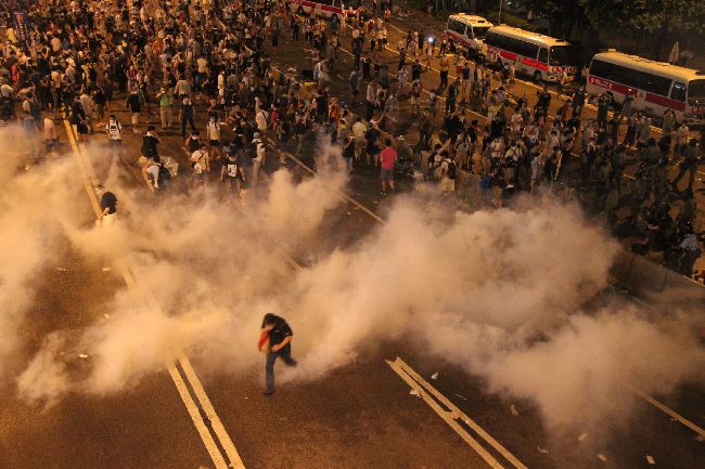 2014年9月底香港爆發大規模的「占領中環運動」,外媒爆料中國軍方曾想干預。 圖為香港警方以催淚彈鎮壓群眾畫面。(圖/中央社)
