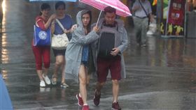 台北降大雨（1）中央氣象局12日上午8時左右發布豪雨特報，因東北風及熱帶性低氣壓外圍雲系影響，宜蘭地區易有局部大豪雨或豪雨，花蓮地區及大台北地區有局部大雨發生的機率，台北上午下起大雨，民眾撐傘快步走。中央社記者吳家昇攝  106年10月12日