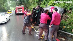 趙女駕駛賓士休旅車行經東山路時，疑因天雨路滑失控撞上燈桿後翻覆，警消獲報趕抵現場，從天窗救出受驚嚇的趙女（翻攝畫面）
