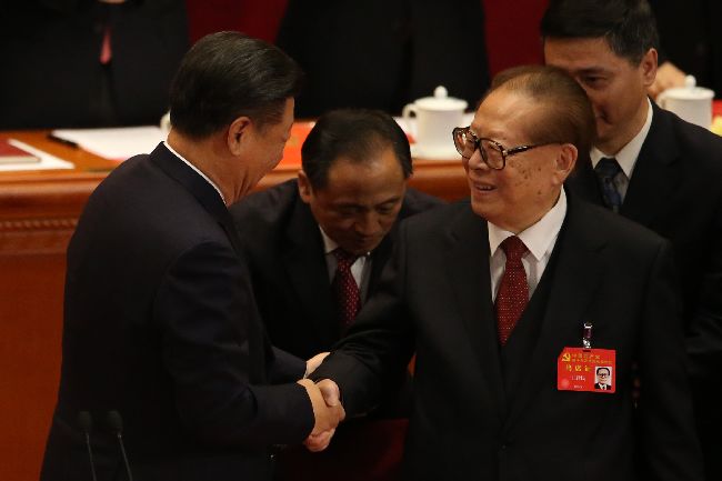 中共19大閉幕式通過中共黨章修正案。「習近平新時代中國特色社會主義思想」列入中共黨章。習近平與前中共領導人江澤民(前右)握手致意