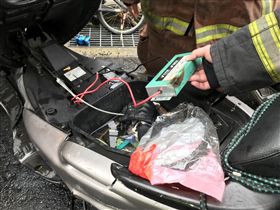 機車後車廂內有改裝電路系統，疑為接觸雨水才會竄出白煙。（圖／翻攝畫面）
