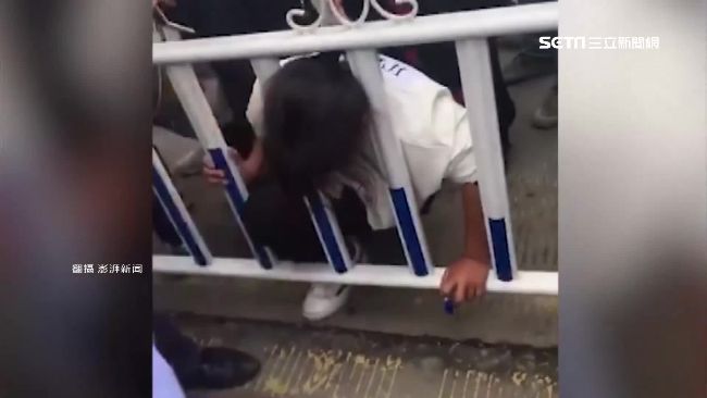 女過馬路跨柵欄　一個翻身頭卡住GG