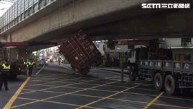 屏東潮州介壽路往東港方向發生一起意外，一輛大型貨櫃車在經過橋底時，竟然卡在橋下，車身還呈現傾斜約45度。貨櫃車司機無奈嘆，「我太遵守交通規則才會卡住啦！」目前已經找來吊車處理現場情況。（圖／翻攝畫面）