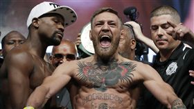 ▲2017年美國時間8月25日在洛杉磯，Conor McGregor（中）與對手Floyd Mayweather Jr.在比賽前一天，在場中先嗆聲，雙方秀出肌肉、眼神交錯展現對陣氣勢。