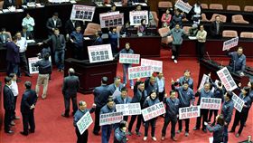 水利會改制付委　國民黨立委反對官派民進黨立法院黨團有意將攸關農田水利會改制為公務機關的農田水利會組織通則部分條文修正草案，擬15日在立法院院會付委審查，國民黨立委上午在議場高舉標語反對水利會官派。中央社記者王飛華攝　106年12月15日