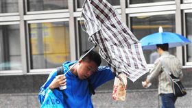 台北持續下雨受東北風與颱風卡努共伴效應持續影響，台灣14日各地都有雨，中央氣象局發布12縣市大雨及豪雨特報，同時發布18縣市陸上強風特報。台北街頭上午不時吹起陣風，有民眾的傘被吹壞。中央社記者施宗暉攝　106年10月14日