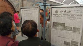 北韓民眾在公告欄看勞動新聞報。（圖／翻攝維基百科）